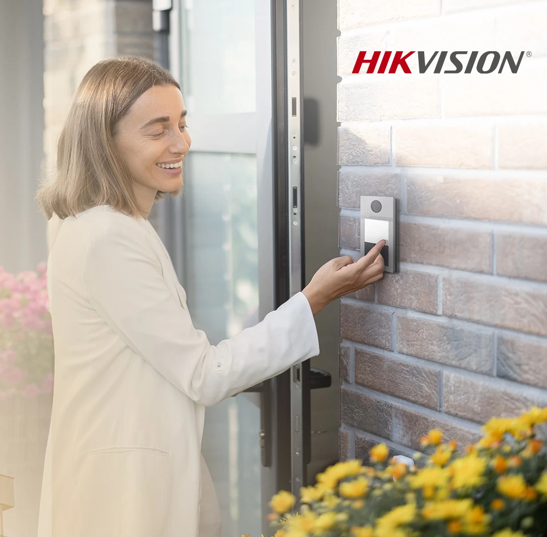 Mujer usando un videoportero Hikvision en la entrada de su casa